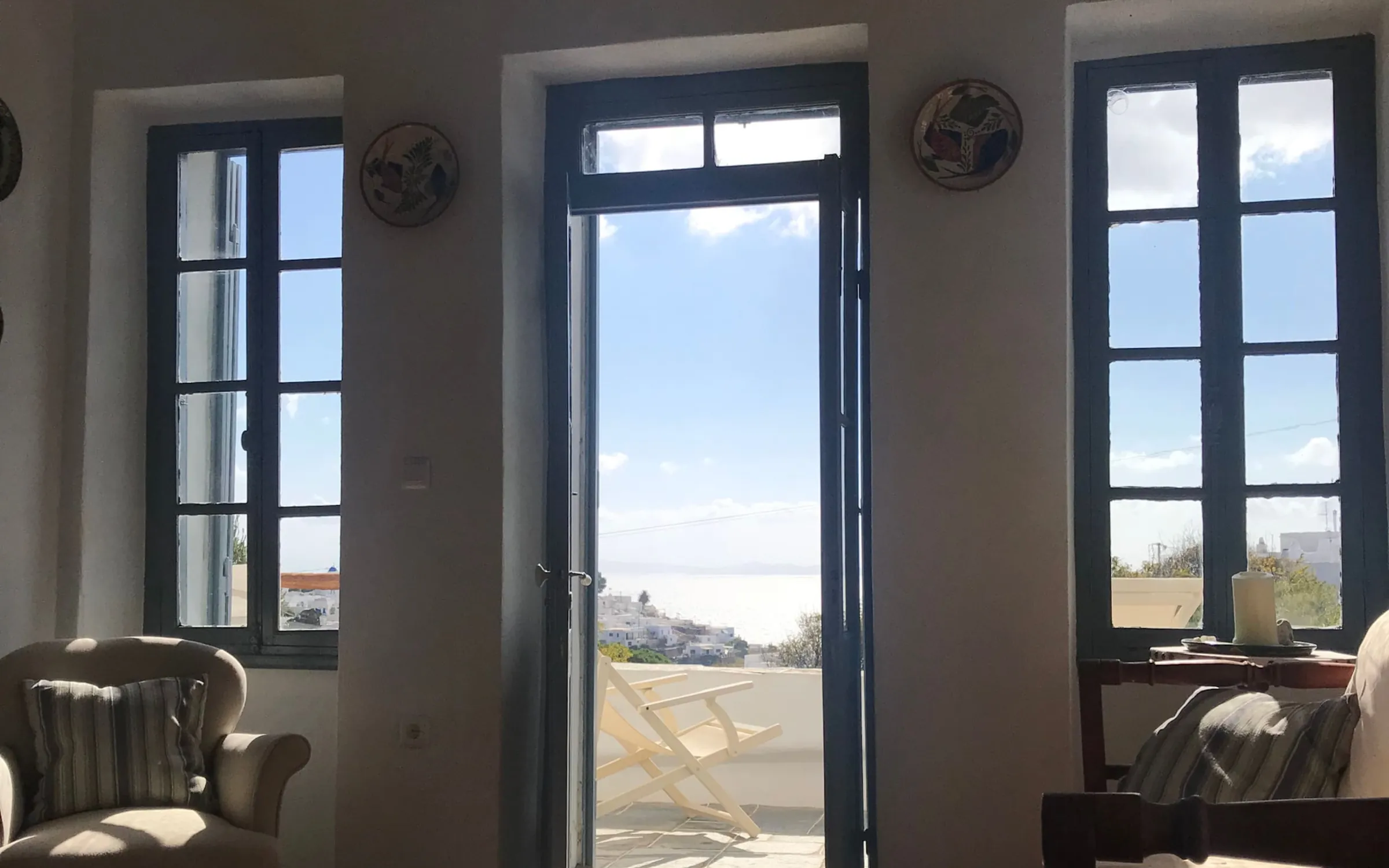 Το σαλόνι του επάνω ορόφου με την πόρτα ανοιχτή προς τη βεράντα και τη θέα
